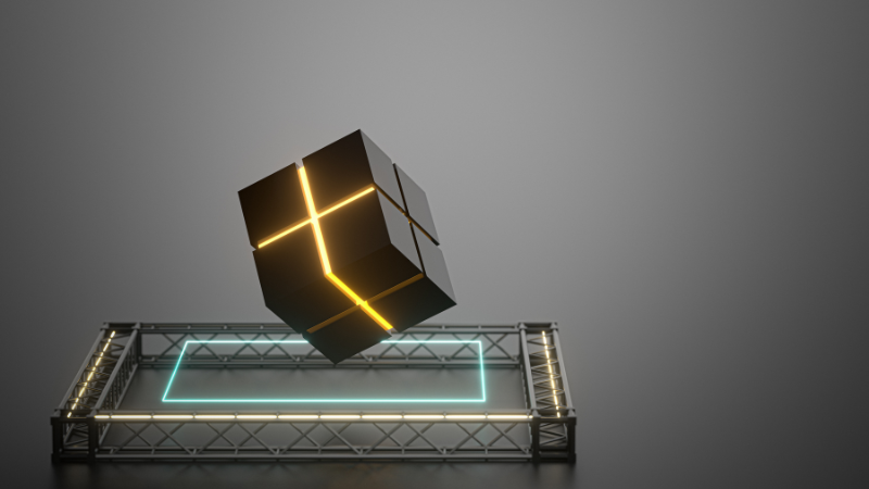 Dark geometric cube with glowing edges floating above a platform against a minimal grey background.