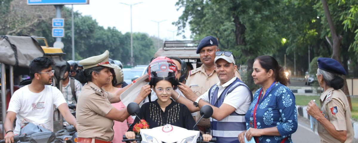 Picture of Chandigarh Traffic Police making a rider wear helmet as part of road safety.