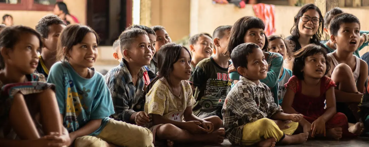 Photo of Indonesian kids squatting on the floor. Photo by Yannis H on Unsplash.