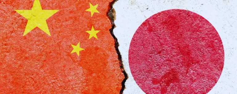 Flags of China and Japan painted on a cracked concrete wall, illustrating the China Japan AI disinformation dispute over wartime history