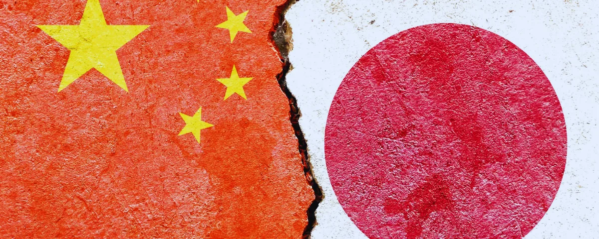 Flags of China and Japan painted on a cracked concrete wall, illustrating the China Japan AI disinformation dispute over wartime history