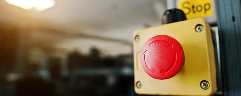 Red emergency stop button on a yellow industrial control box, illustrating the AI Kill Switch Act introduced in the US Congress.