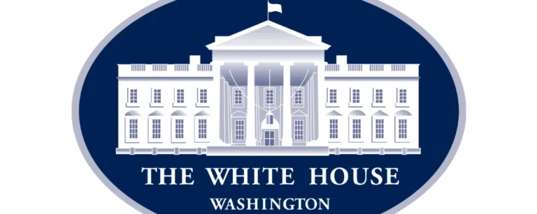Illustration of the White House logo featuring a white silhouette of the White House on a dark blue oval background with the words "The White House, Washington."