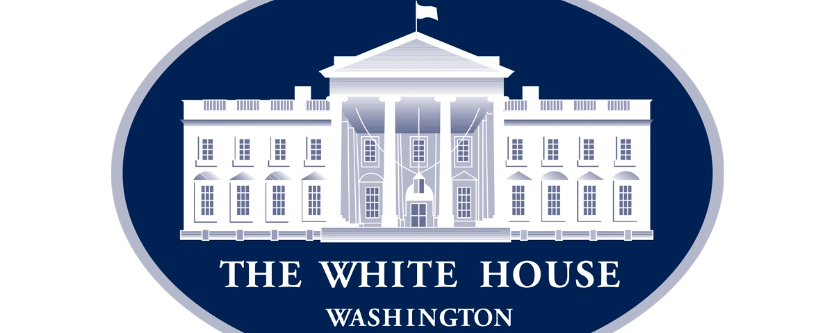 Illustration of the White House logo featuring a white silhouette of the White House on a dark blue oval background with the words "The White House, Washington."
