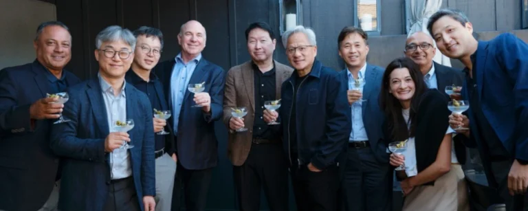 A group of executives from SK Group and NVIDIA pose together at a networking event, holding cocktail glasses and smiling for a photo following the announcement of their expanded strategic partnership in AI infrastructure and next-generation memory.