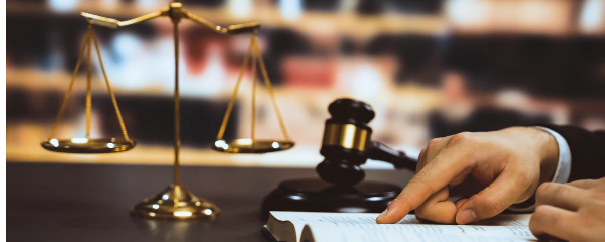 Close-up of a judge's gavel, balanced scales of justice and a legal document, symbolizing the use of artificial intelligence and benchmarking in the legal profession.