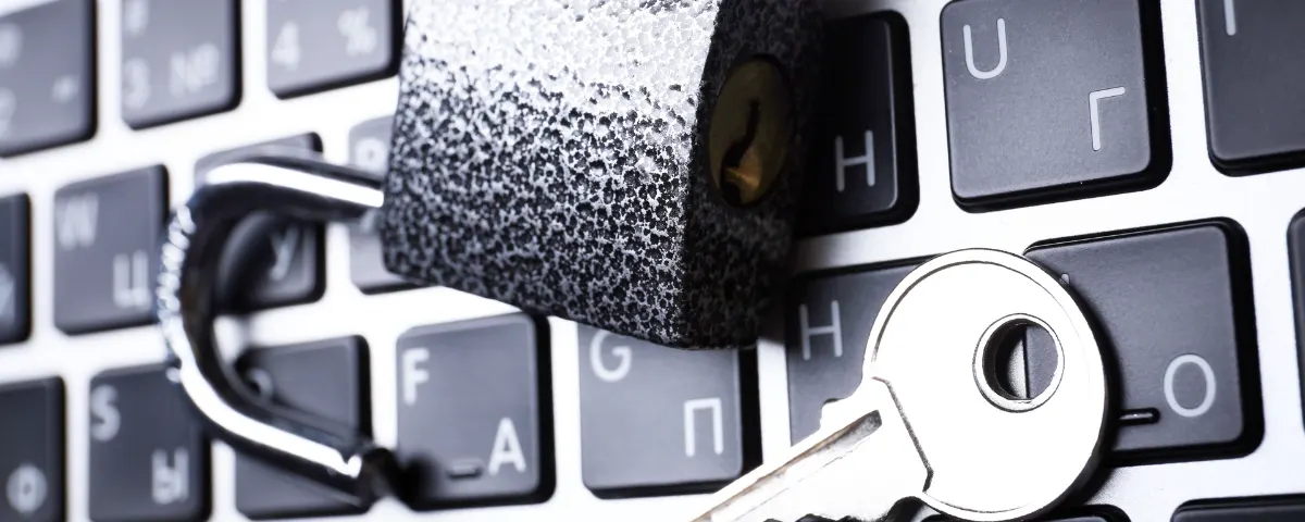 Open padlock and key resting on a laptop keyboard representing AI privacy and data security risks