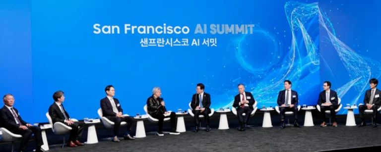 Panel discussion at the San Francisco AI Summit with South Korean President Lee Jae Myung and tech executives seated on stage in front of a blue "San Francisco AI Summit" backdrop.