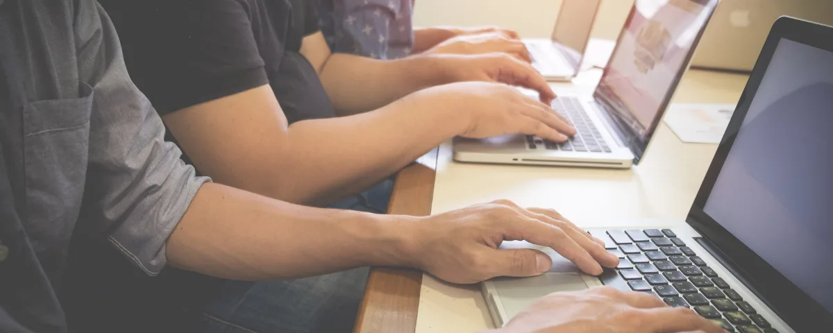 People receiving computer and cloud technology training on laptops.