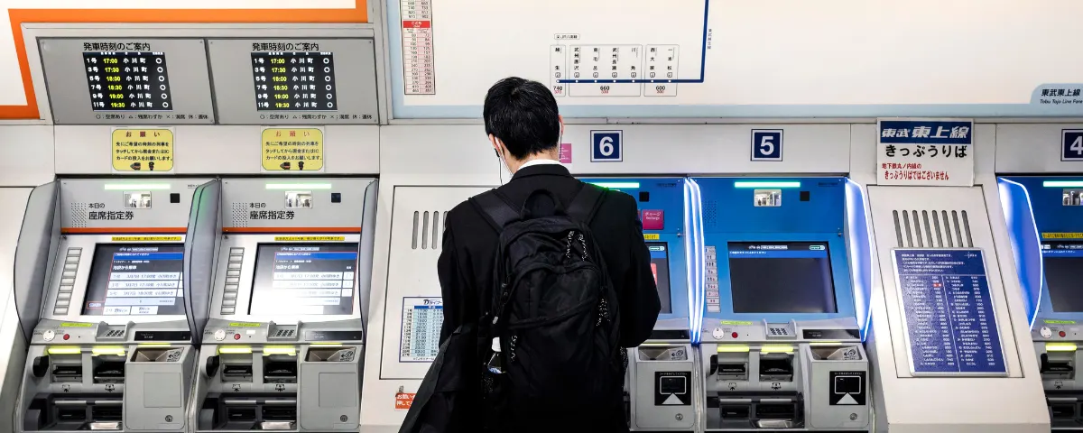 Commuter using a ticket machine at a railway station in Japan