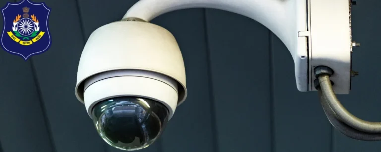 White dome CCTV camera mounted on a wall bracket, with the Gujarat Police emblem in the corner