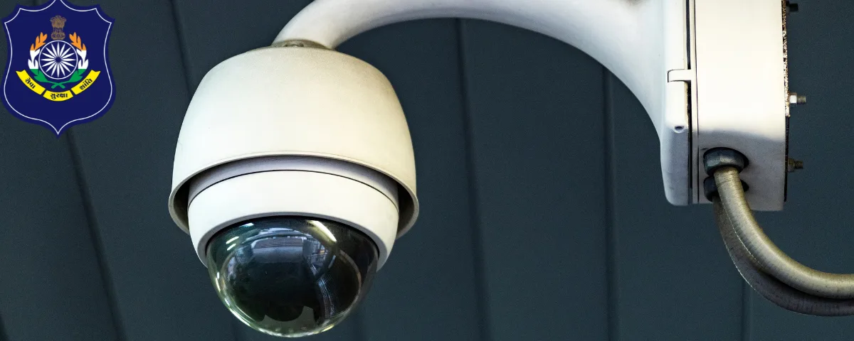 White dome CCTV camera mounted on a wall bracket, with the Gujarat Police emblem in the corner