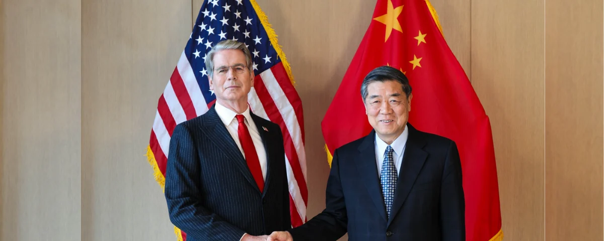 US and Chinese officials standing between US and Chinese flags during bilateral talks