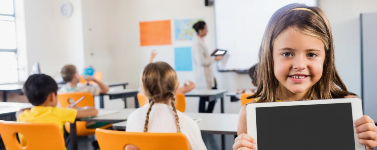 Student holding a tablet in a classroom, illustrating the use of technology in schools amid new AI safety and privacy protections.