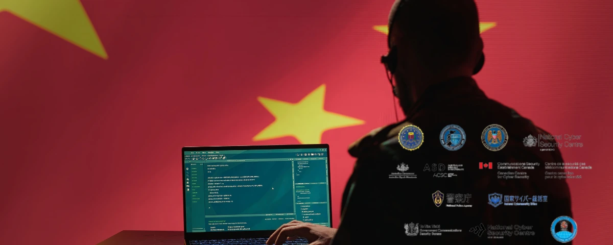 Silhouette of a person working at a laptop against a Chinese flag, overlaid with logos of US and international cybersecurity agencies.