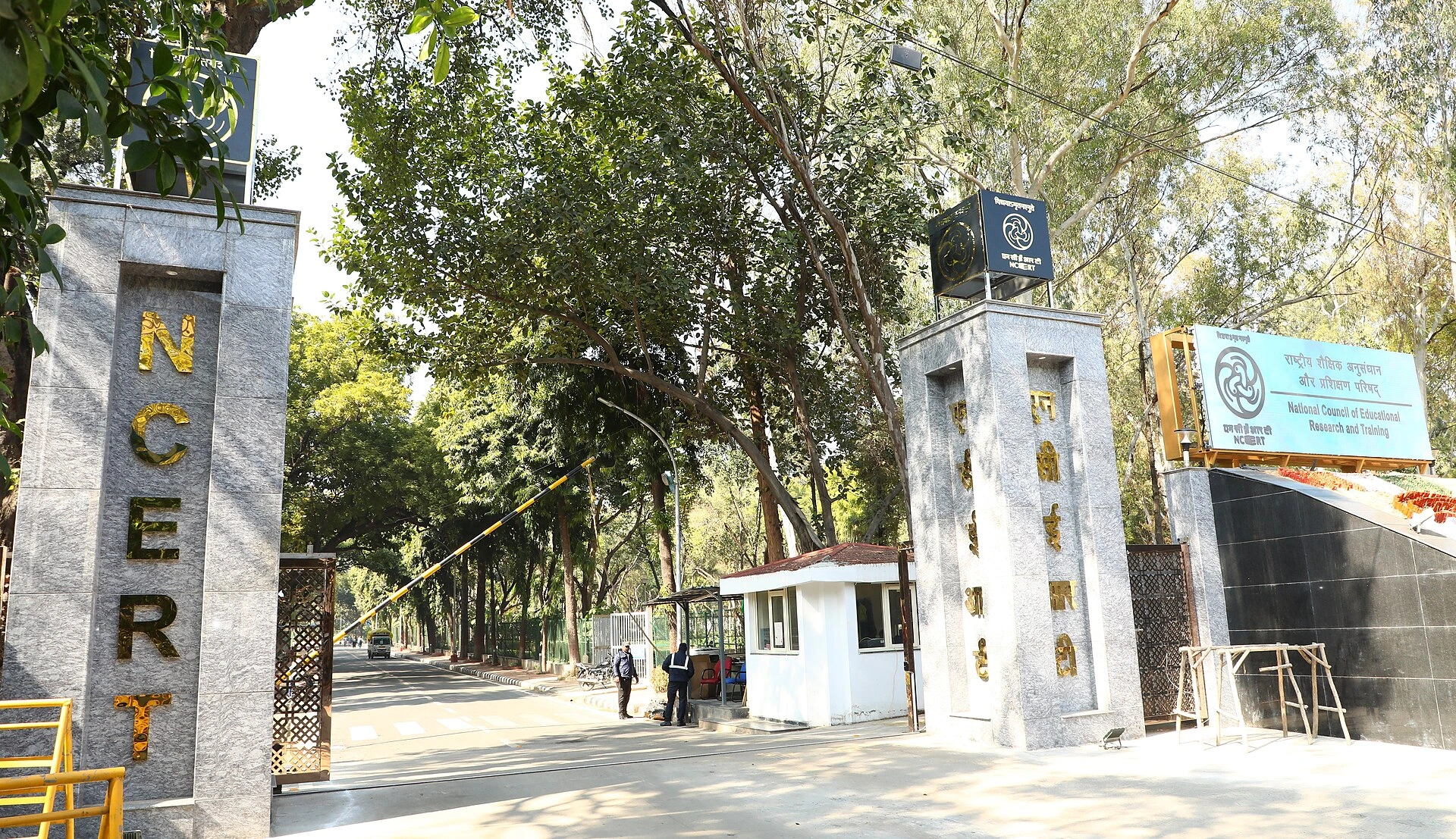 Entrance gate of the National Council of Educational Research and Training (NCERT) campus, with the NCERT signboard and surrounding trees.